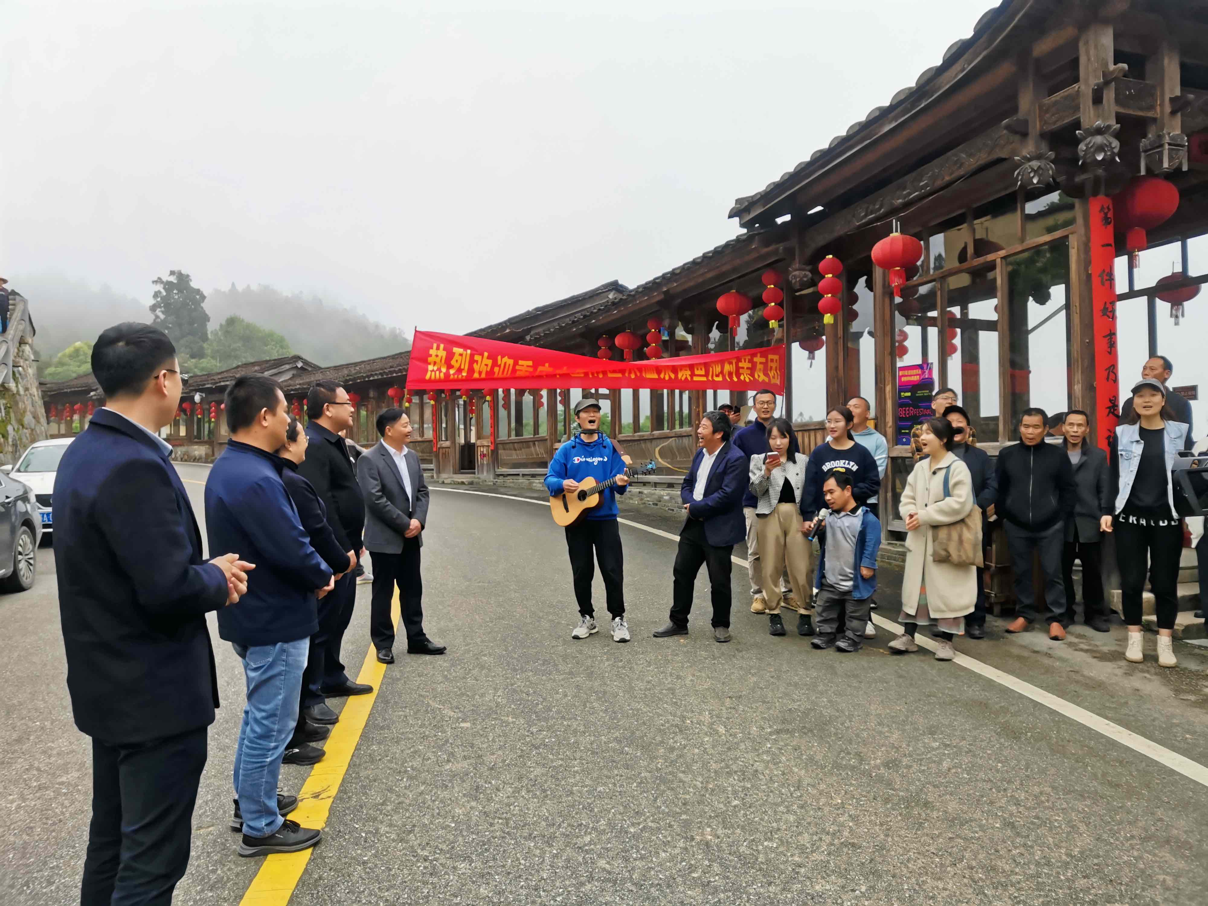 四坪村民唱村歌迎接鱼池村的朋友.jpg
